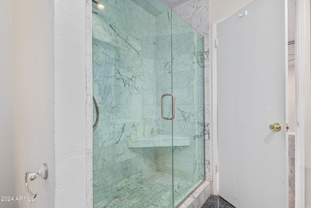 bathroom with a marble finish shower