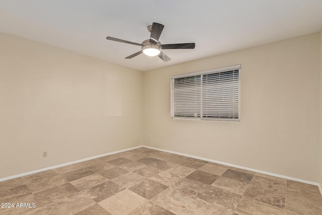 spare room with baseboards and a ceiling fan