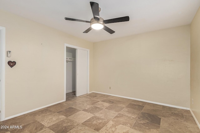 unfurnished bedroom with stone finish flooring, baseboards, a closet, and ceiling fan