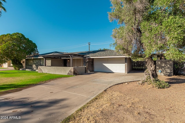 single story home featuring a front lawn, fence, concrete driveway, stucco siding, and a garage