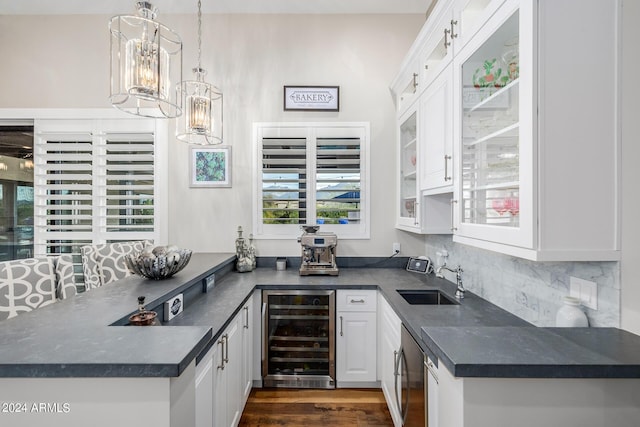 kitchen with sink, tasteful backsplash, wine cooler, pendant lighting, and white cabinets