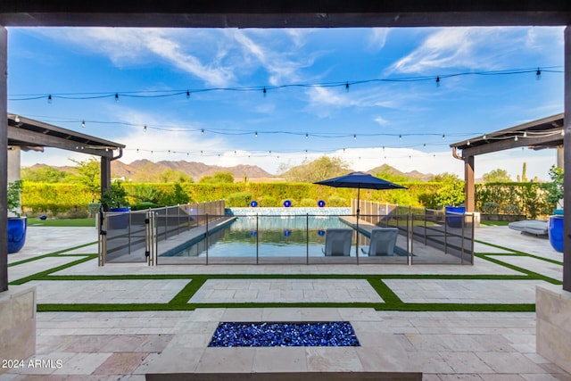 view of pool featuring a mountain view, a patio, and a fire pit