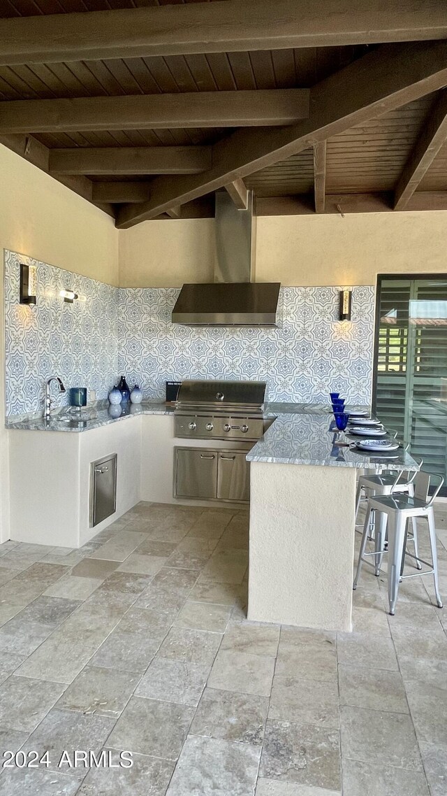 view of patio / terrace featuring a grill, a wet bar, and an outdoor kitchen