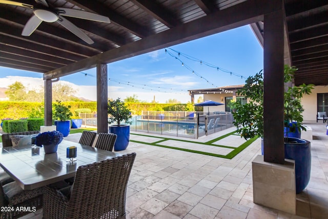 view of patio with ceiling fan, a fenced in pool, and a mountain view