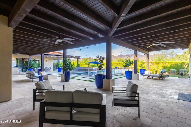 view of patio with ceiling fan, a mountain view, and an outdoor living space