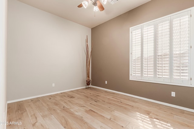 empty room with ceiling fan and light hardwood / wood-style flooring