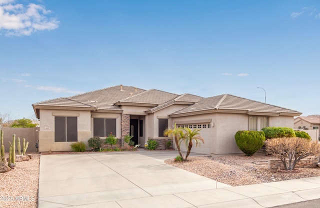 prairie-style house with a tile roof, a garage, and stucco siding