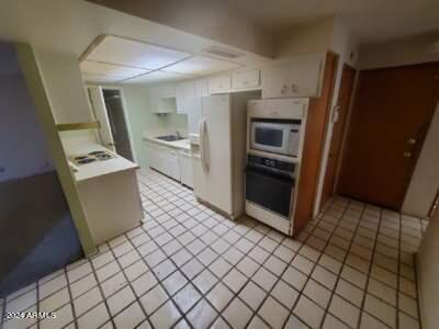 kitchen with light tile patterned floors and white appliances
