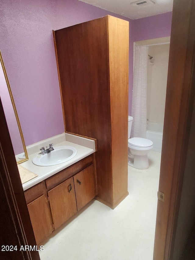 bathroom featuring tile patterned floors, toilet, vanity, and shower / bath combo with shower curtain