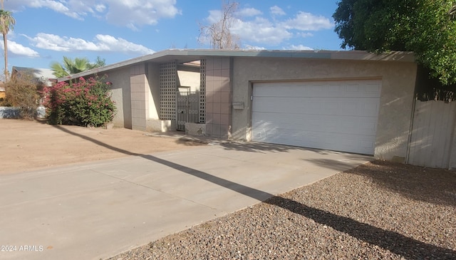 exterior space featuring stucco siding, a garage, and concrete driveway