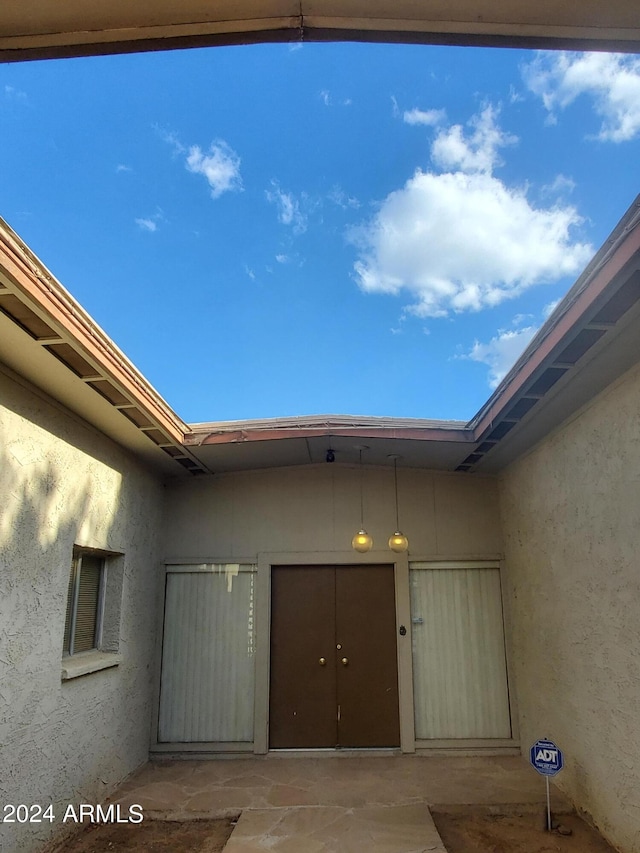 doorway to property featuring stucco siding