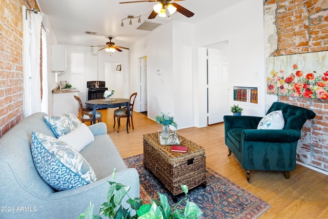 living room with hardwood / wood-style flooring and brick wall