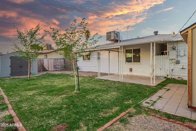 117 Peretz Cir, Morristown, AZ 85342 - back of house with a patio area, an outdoor structure, a storage shed, a fenced backyard, and a lawn