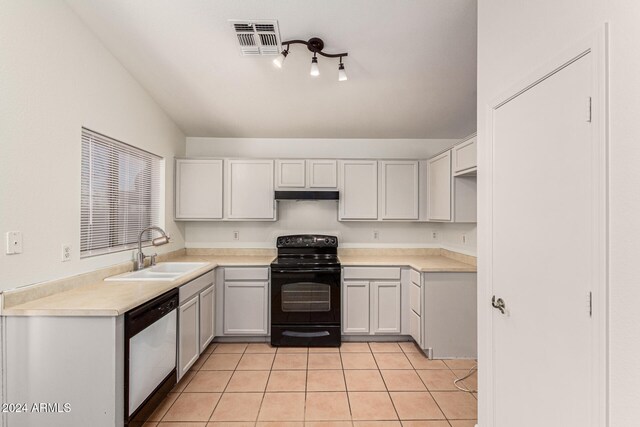 kitchen featuring stainless steel dishwasher, sink, light tile patterned floors, white cabinets, and black electric range oven