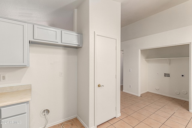 clothes washing area featuring hookup for a gas dryer, light tile patterned floors, washer hookup, and hookup for an electric dryer