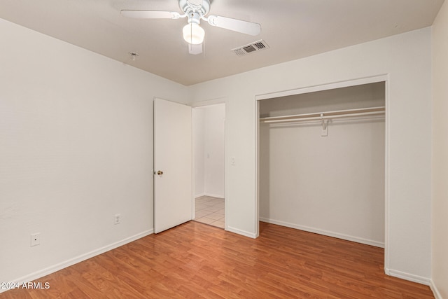 unfurnished bedroom with ceiling fan, a closet, and light hardwood / wood-style floors