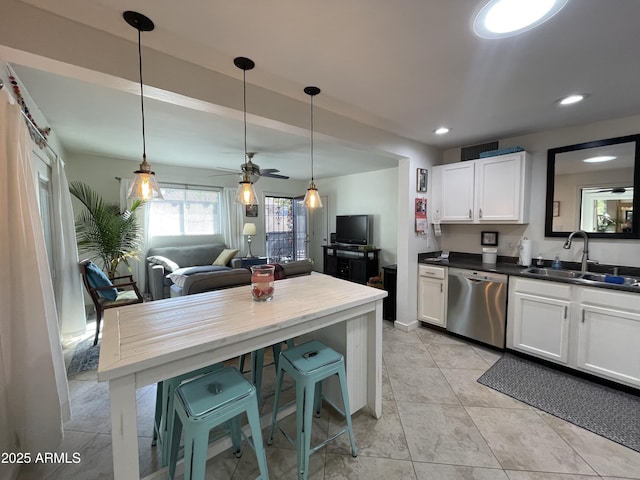 kitchen featuring dark countertops, a sink, white cabinetry, and dishwasher