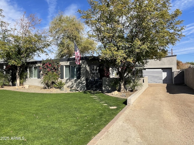 view of front of home with a garage, driveway, a front lawn, and stucco siding