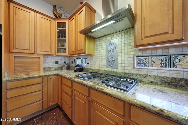 kitchen featuring backsplash, stainless steel gas stovetop, light stone countertops, and wall chimney exhaust hood