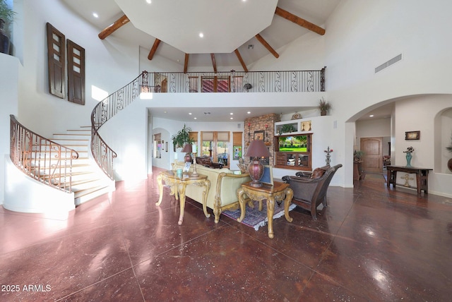 living room featuring beam ceiling and a high ceiling