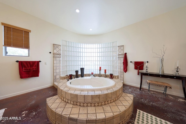 bathroom with a relaxing tiled tub