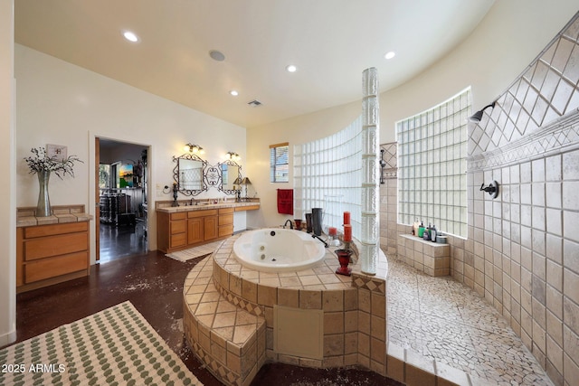 bathroom with vanity, tiled tub, and a wealth of natural light