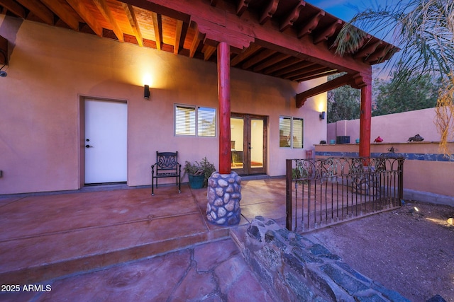 patio terrace at dusk featuring french doors