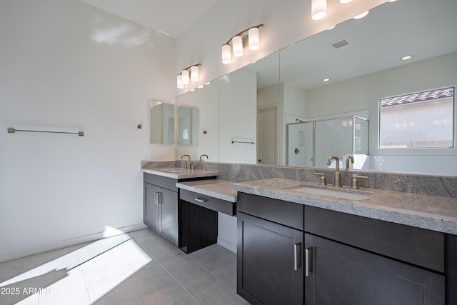 bathroom with tile patterned floors, visible vents, a stall shower, and a sink