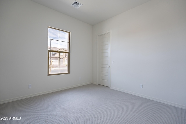 empty room featuring visible vents, light colored carpet, and baseboards