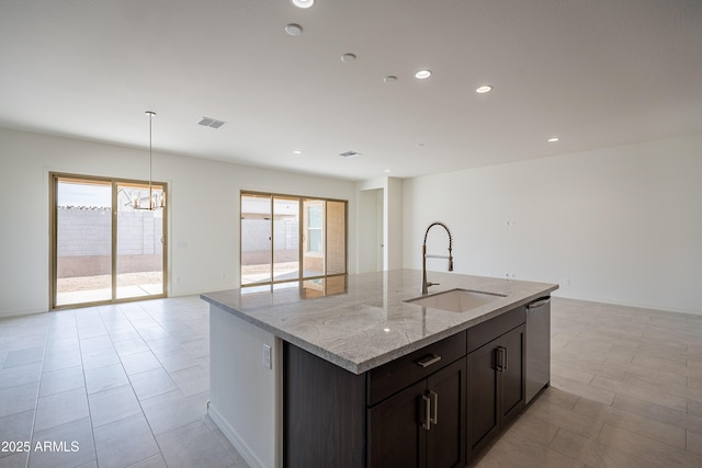 kitchen featuring stainless steel dishwasher, plenty of natural light, open floor plan, and a sink