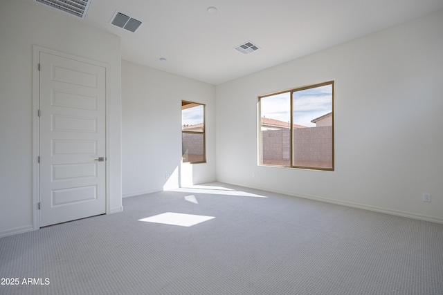 empty room featuring baseboards, visible vents, and carpet floors
