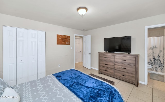 tiled bedroom featuring a closet and ensuite bath