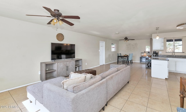 living room featuring ceiling fan, sink, and light tile patterned floors