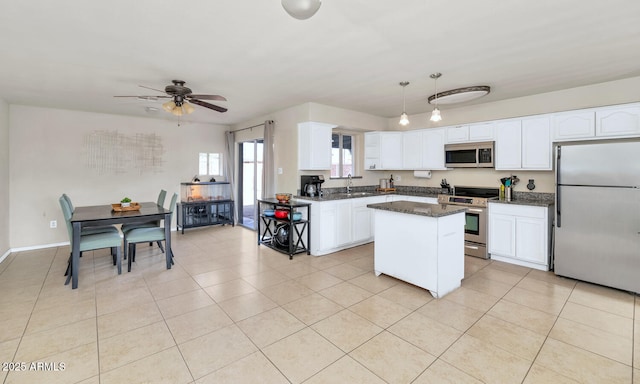 kitchen with a center island, stainless steel appliances, white cabinets, pendant lighting, and light tile patterned flooring