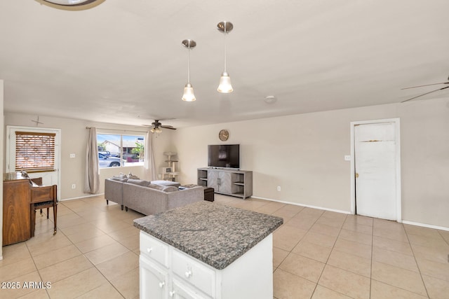 kitchen with ceiling fan, white cabinets, dark stone counters, decorative light fixtures, and light tile patterned floors