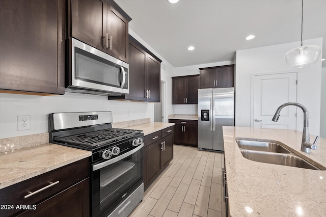 kitchen featuring sink, stainless steel appliances, and light stone countertops