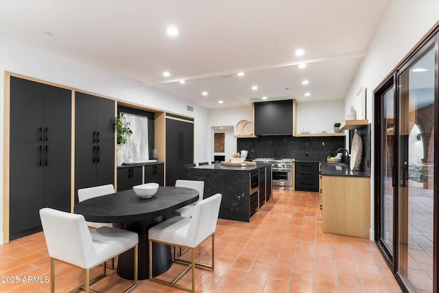 kitchen with sink, a center island, tasteful backsplash, ventilation hood, and light tile patterned flooring