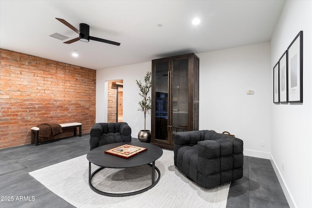 living room featuring ceiling fan and brick wall