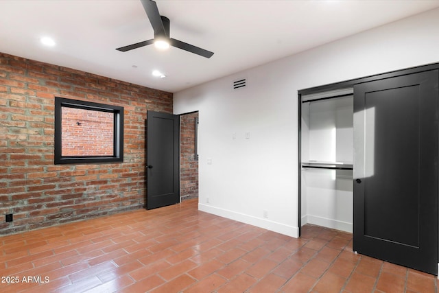 unfurnished bedroom with brick wall and ceiling fan