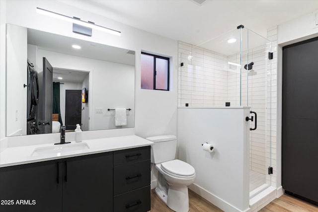 bathroom featuring walk in shower, vanity, toilet, and hardwood / wood-style floors