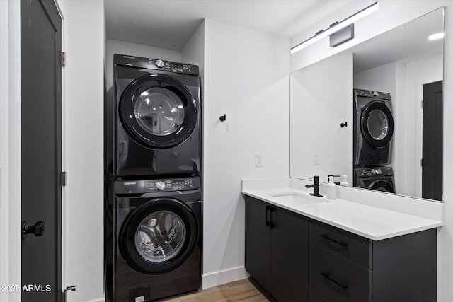 laundry room with stacked washer and clothes dryer, sink, and light hardwood / wood-style flooring