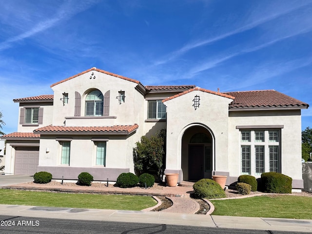 mediterranean / spanish-style house with a garage and a front yard