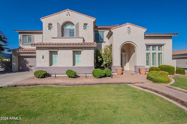 1912 E Gemini Pl, Chandler, AZ 85249 - mediterranean / spanish-style house with a garage, a tile roof, stucco siding, and a front lawn