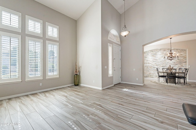 1912 E Gemini Pl, Chandler, AZ 85249 - entryway featuring high vaulted ceiling, arched walkways, a chandelier, wood finished floors, and baseboards