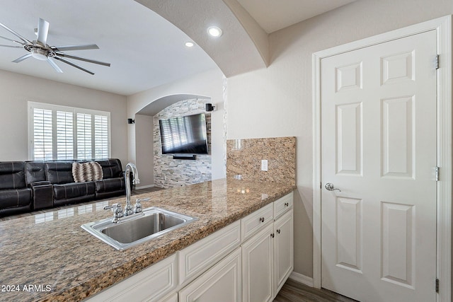 kitchen with decorative backsplash, sink, dark hardwood / wood-style floors, white cabinetry, and dark stone countertops