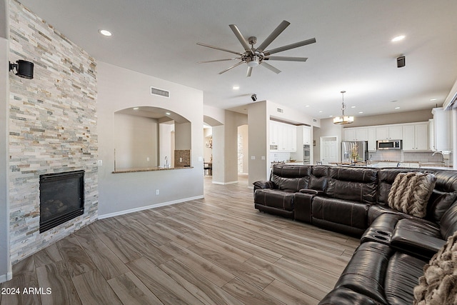 1912 E Gemini Pl, Chandler, AZ 85249 - living room featuring ceiling fan, a stone fireplace, light wood-type flooring, baseboards, and recessed lighting