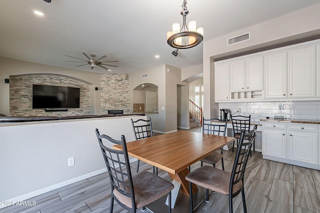 dining area featuring ceiling fan with notable chandelier and light hardwood / wood-style flooring