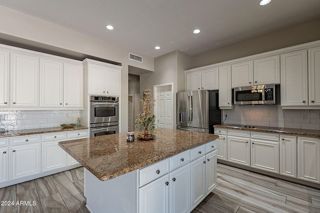 1912 E Gemini Pl, Chandler, AZ 85249 - kitchen featuring stainless steel appliances, white cabinetry, tasteful backsplash, a center island, and recessed lighting