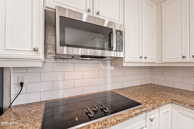 1912 E Gemini Pl, Chandler, AZ 85249 - kitchen with stainless steel microwave, black electric cooktop, white cabinetry, backsplash, and dark stone countertops