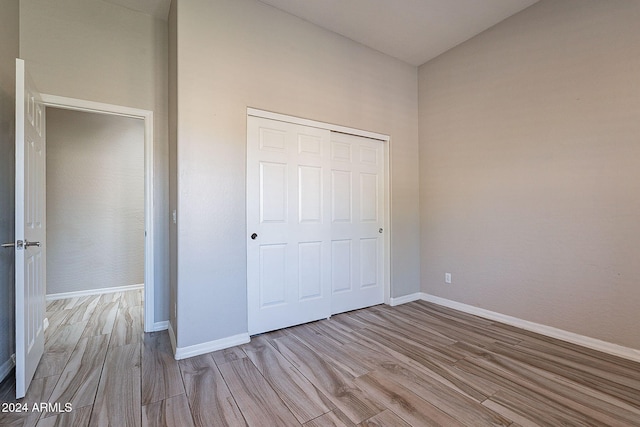 unfurnished bedroom featuring a closet and light hardwood / wood-style floors